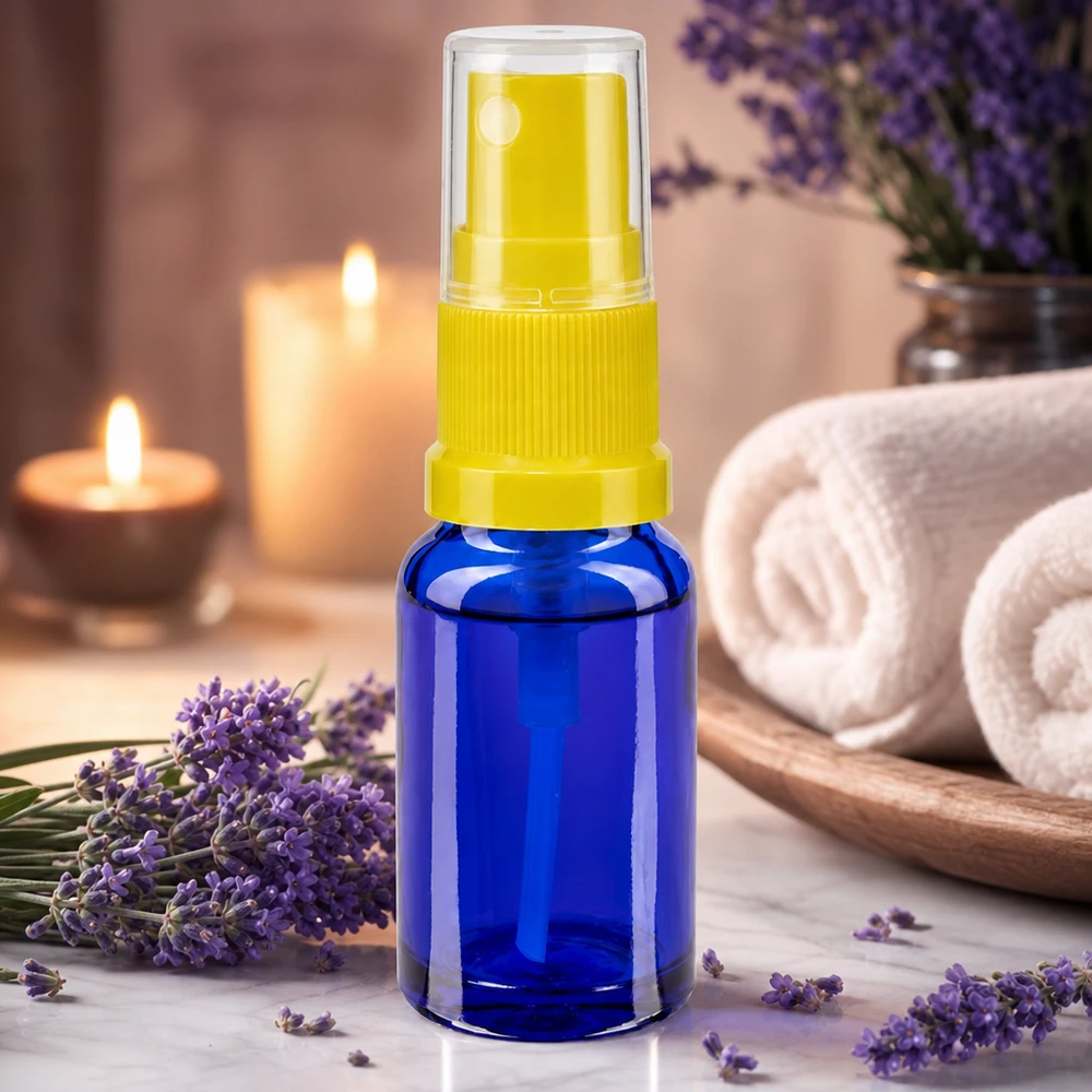 Flacon vaporisateur rechargeable de 30 ml en verre de pharmacie bleu, muni d'une pompe vaporisatrice jaune