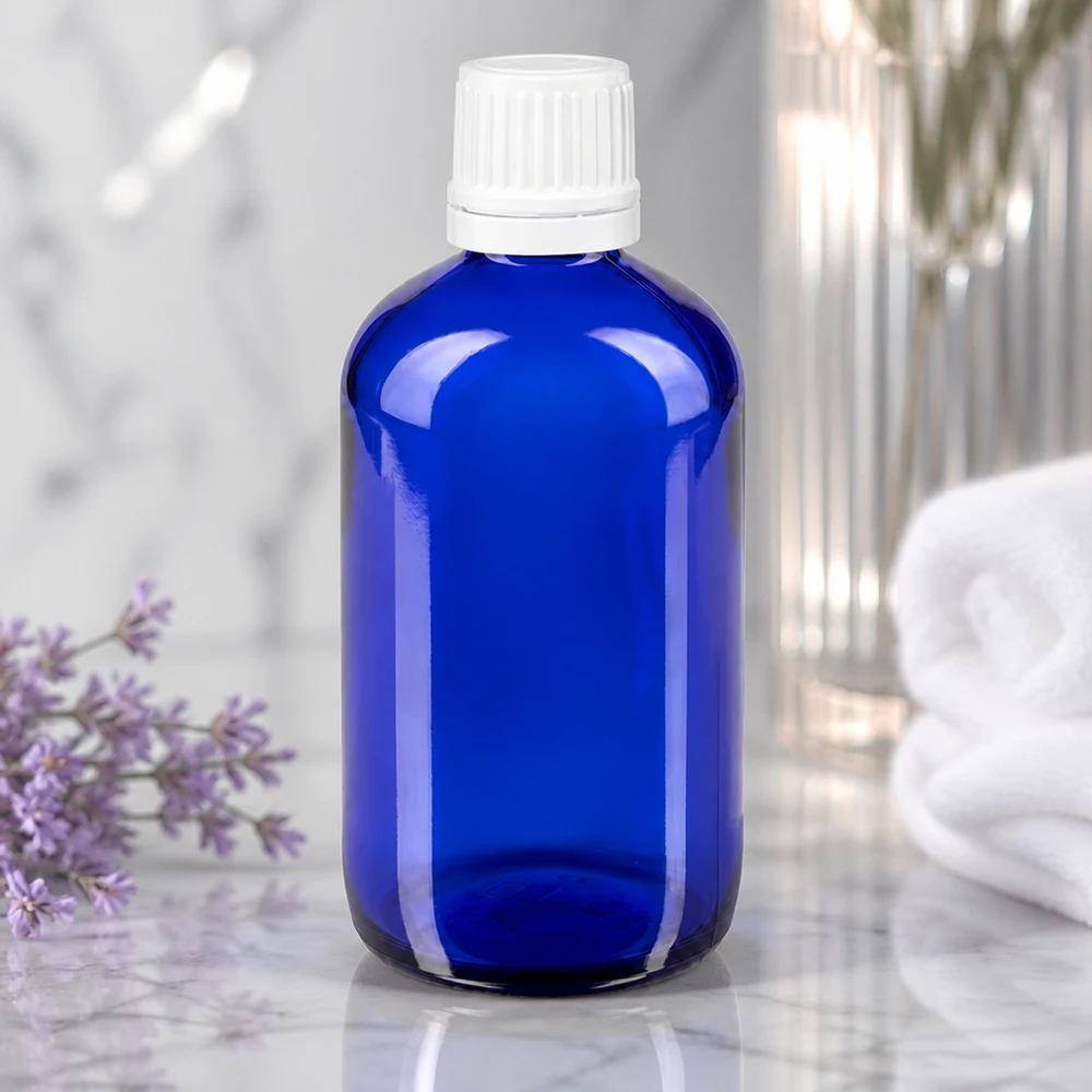Flacon en verre bleu de 20 ml muni d'un embout compte-gouttes de 1,2 mm et d'un bouchon à vis blanc à sécurité enfant