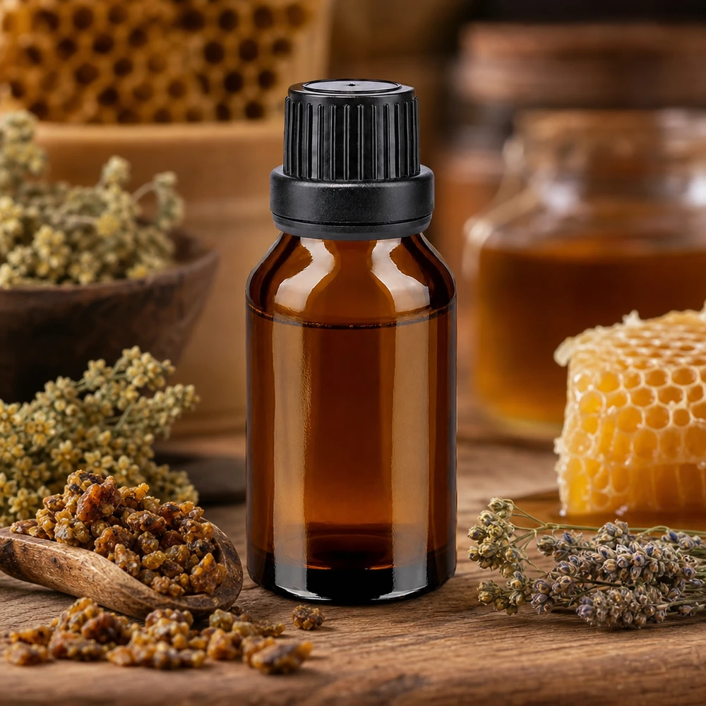 Flacon cylindrique en verre ambré de 15 ml, muni d'un bouchon à vis noir, entouré de produits apicoles