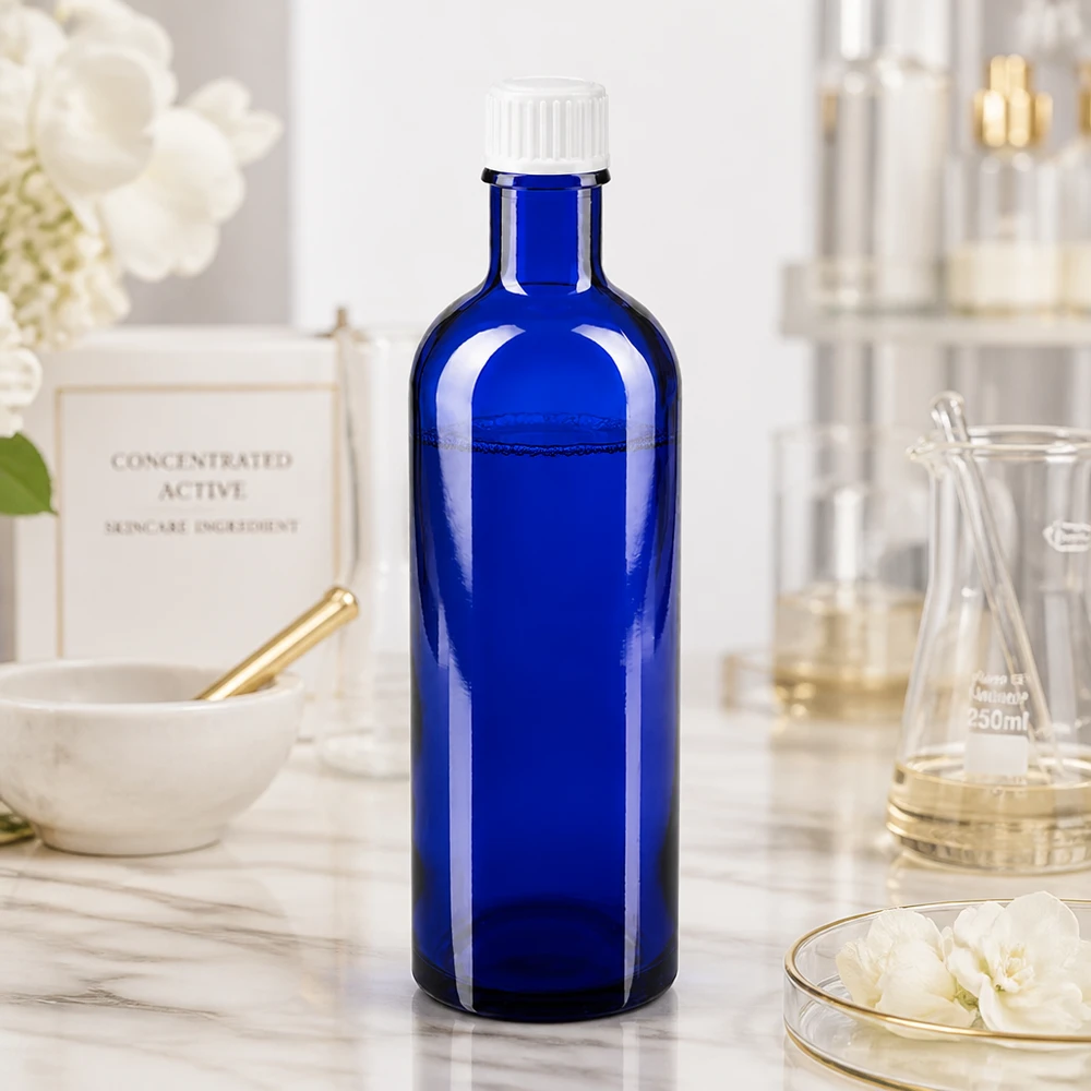 Flacon de pharmacie bleu 200ml bouchon vissable blanc standart Flacon rectangulaire en verre bleu de 200 ml avec bouchon à vis blanc strié, destiné aux produits cosmétiques