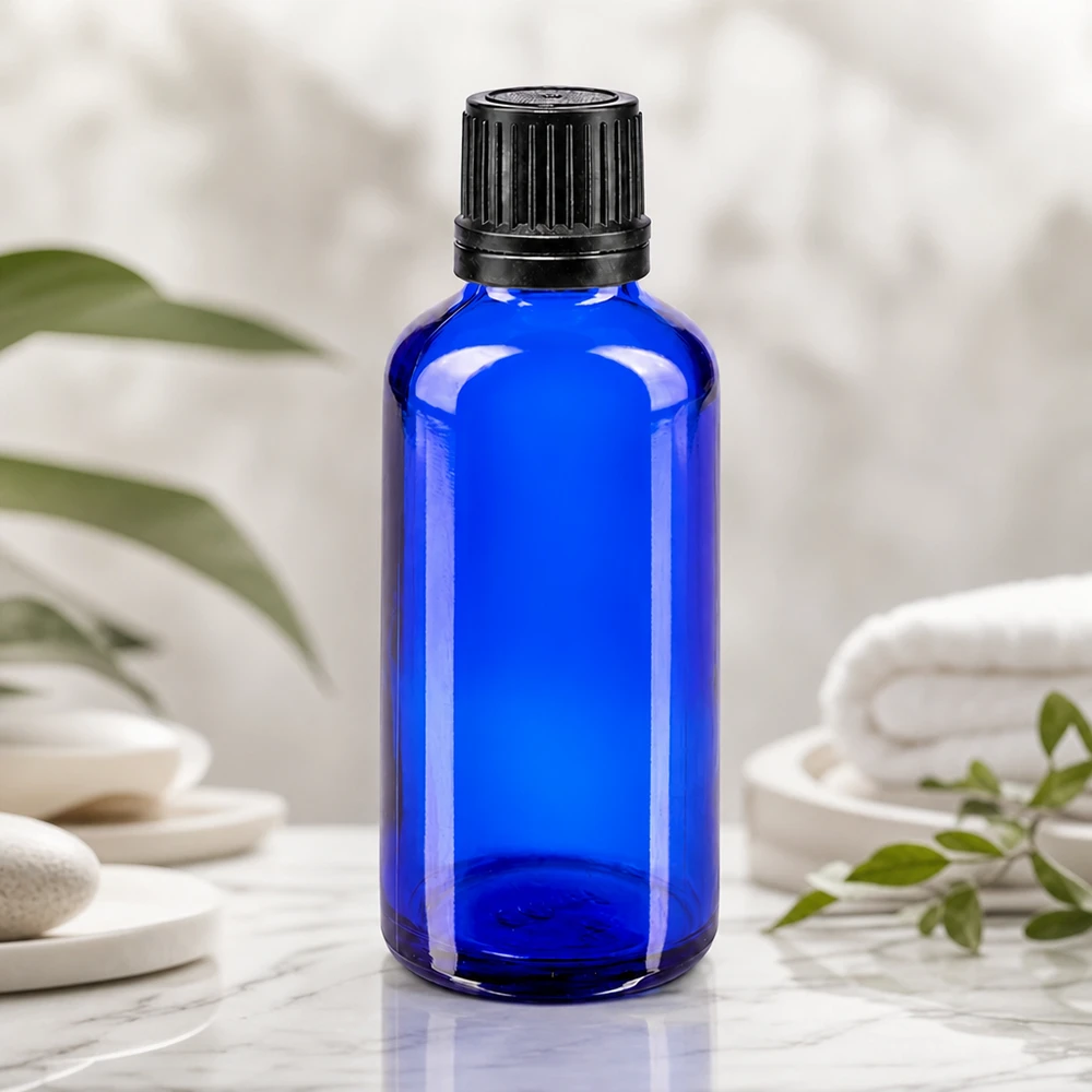 Flacon à pharmacie bleu 50ml bouchon inviolable 1mm noir bouchon d'inviolabilité Flacon en verre d'apothicaire bleu cobalt de 50 ml avec un bouchon OV noir, posé sur une surface en marbre blanc