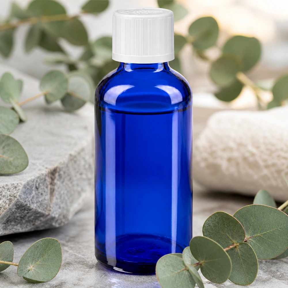 Flacon à pharmacie bleu 50ml bouchon anti-goutte blanc séc. enf. std Flacon Apoglas bleu de 50 ml avec bouchon de sécurité enfant et eucalyptus dans une ambiance bien-être