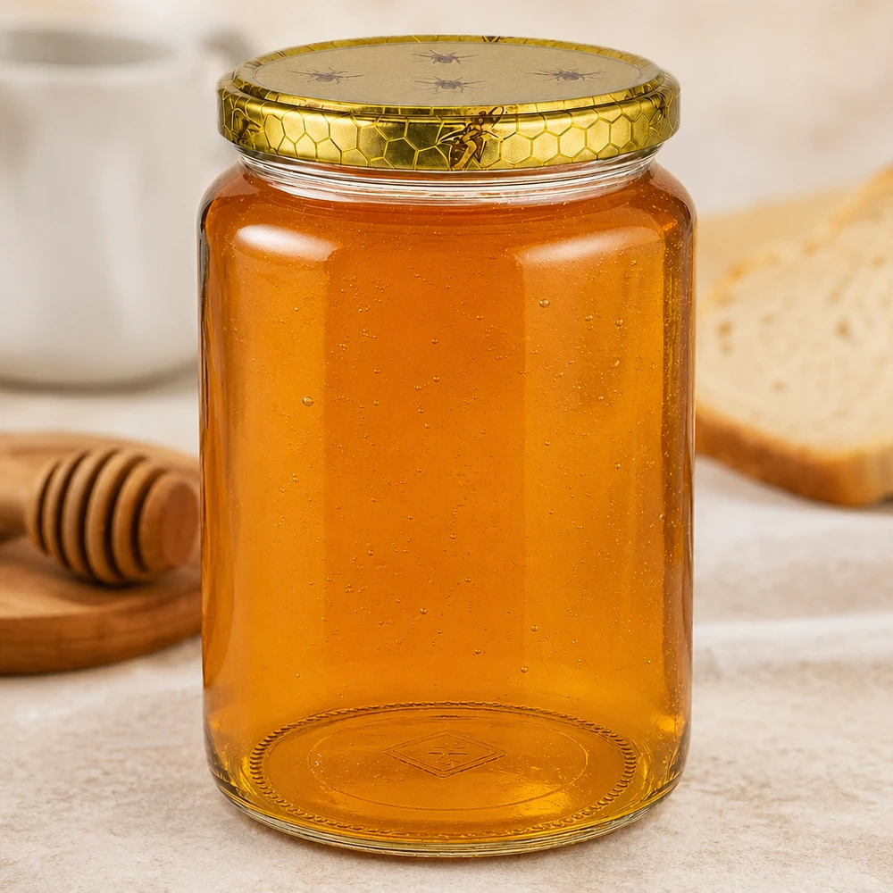 Grand pot de miel de 1000g avec gaufrage au fond à côté de la baguette de miel et du pain sur une planche en bois Scène de cuisine Matériel d'apiculture
