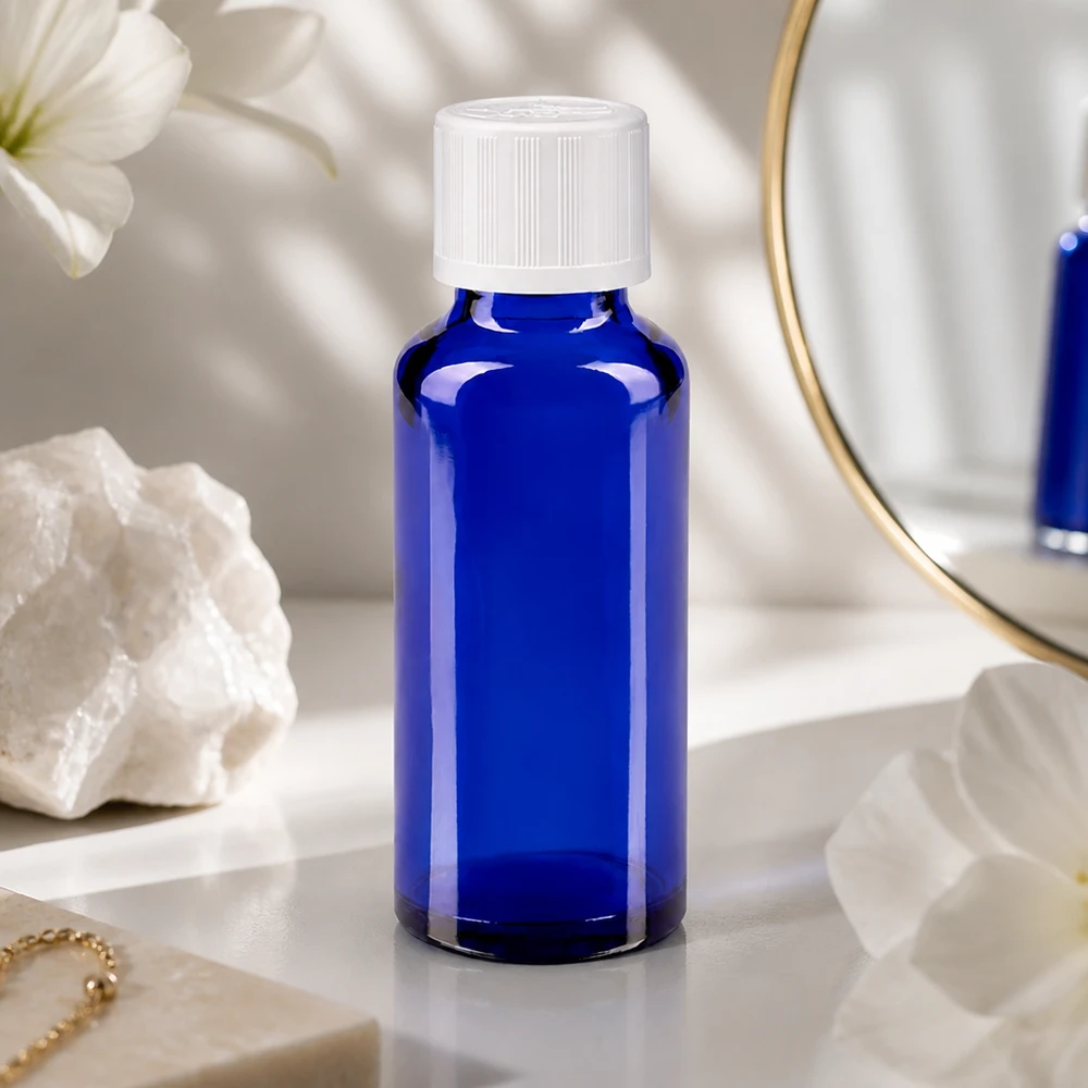 Flacon à pharmacie bleu 30ml bouchon vissable blanc sécurité enfant Flacon en verre bleu de 30 ml muni d'un bouchon à vis à l'épreuve des enfants, à côté d'un cristal et d'un bijou en or