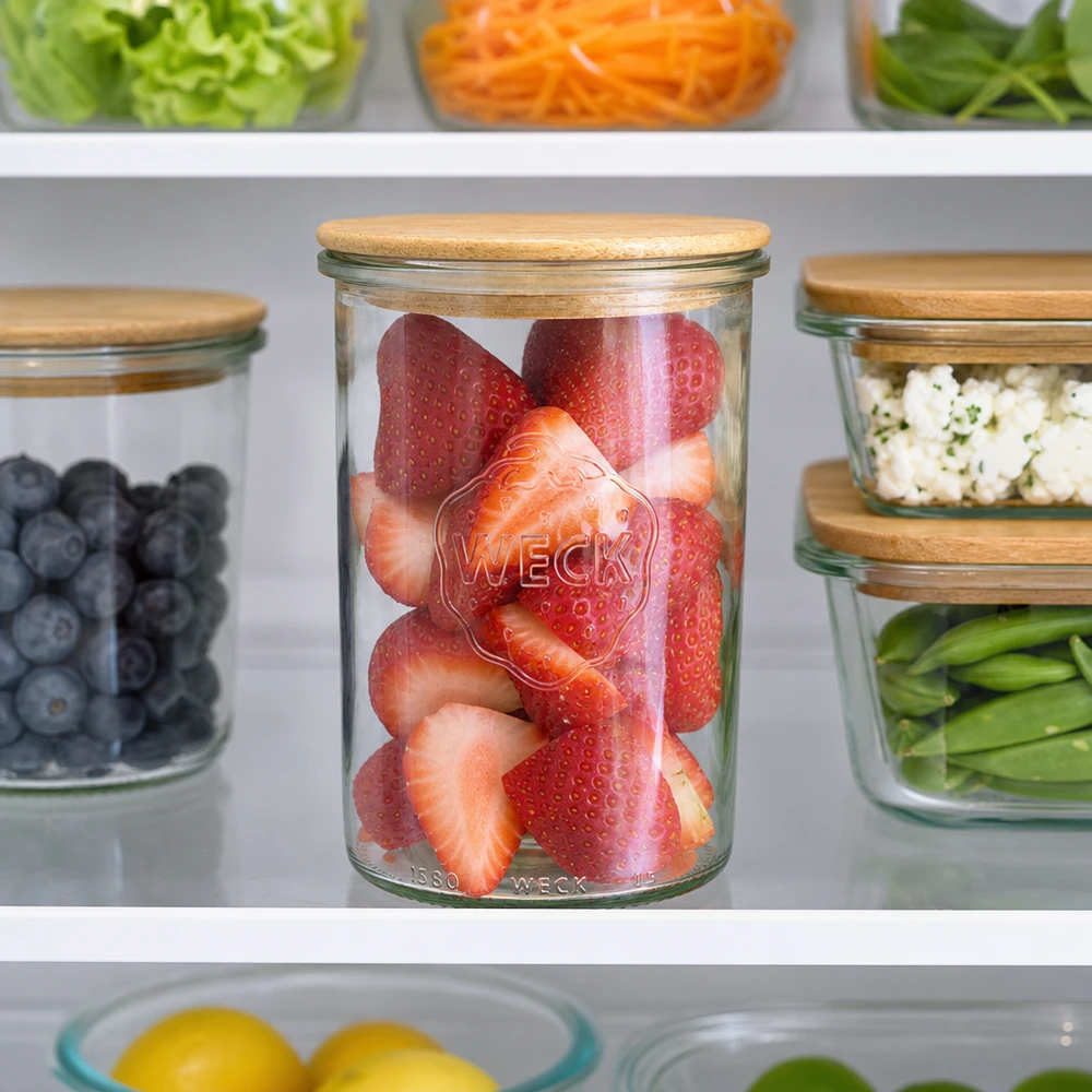 1000ml bocal conique WECK RR100 avec couvercle en bois WECK Bocal à provisions 1000ml avec couvercle en bois rempli de fraises dans le réfrigérateur à côté des myrtilles et des légumes