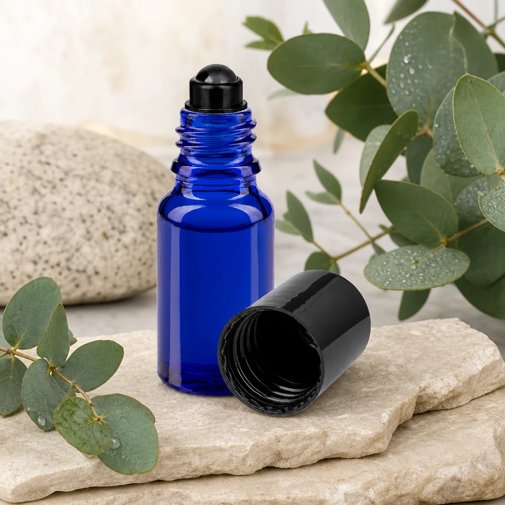 Flacon de déodorant en verre bleu 10 ml, déo à bille vide Flacon en verre bleu cobalt à bille de 10 ml, avec une bille en acier inoxydable nichée entre des pierres et des feuilles d'eucalyptus fraîches