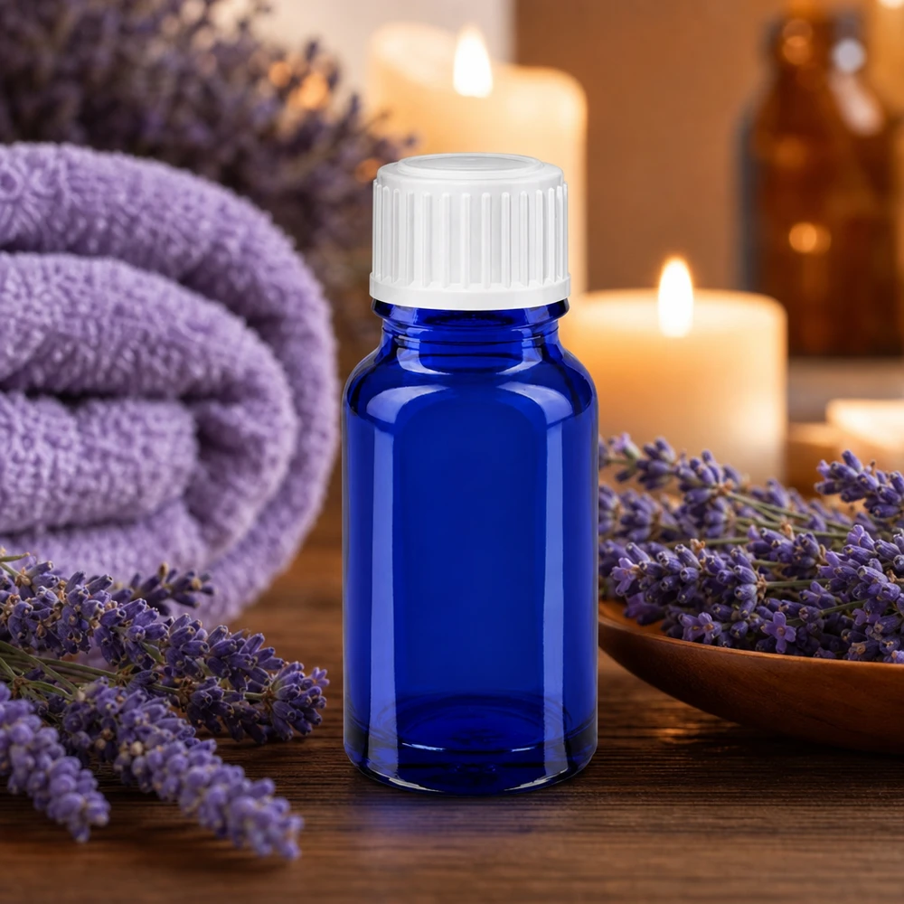 Petit flacon d'aromathérapie bleu cobalt de 10 ml avec bouchon à vis blanc, dans une ambiance spa