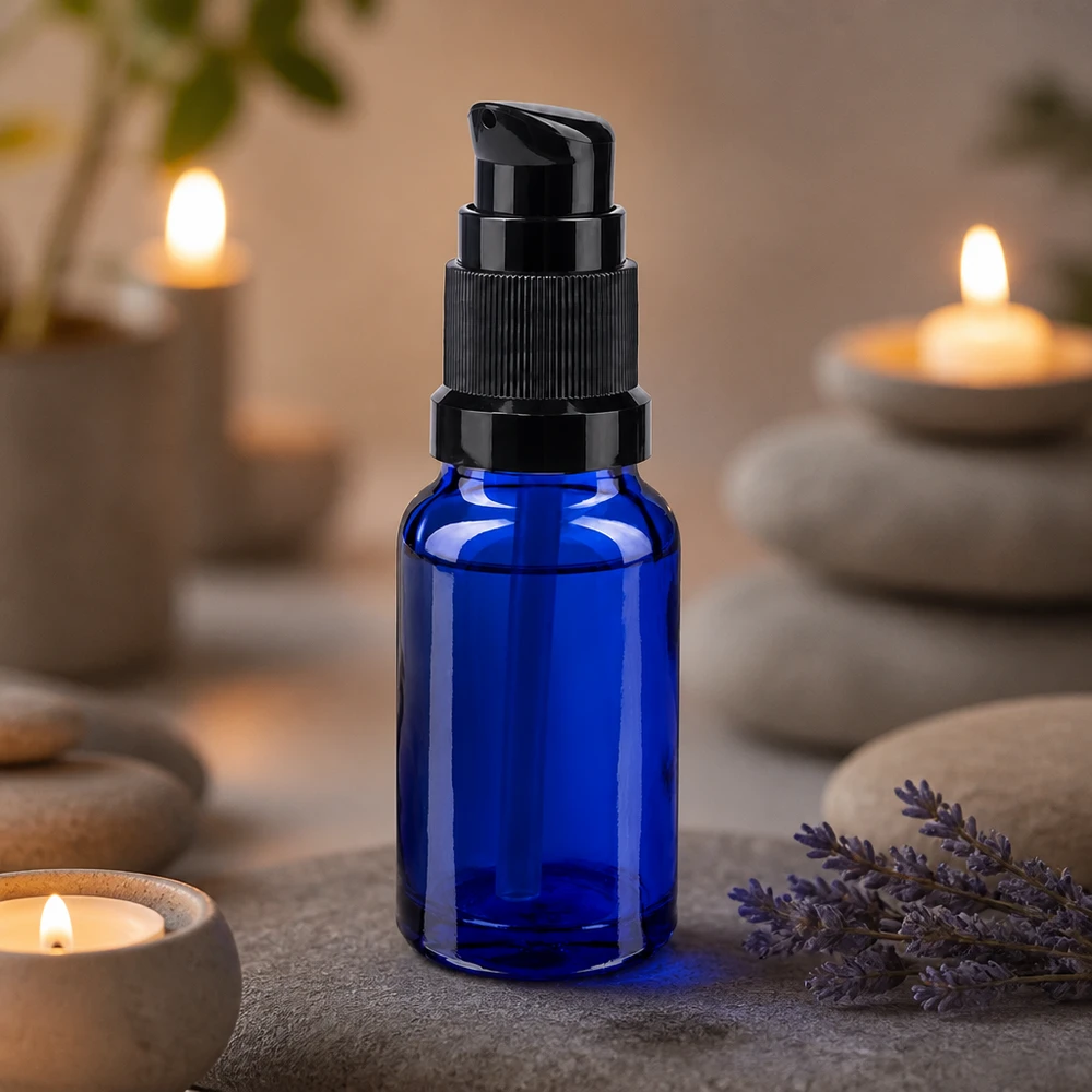 Flacon de pharmacie bleu 10ml bouchon pompe noir standart Flacon pompe bleu cobalt de 10 ml, modèle STD noir, dans un décor de bien-être avec des pierres de spa