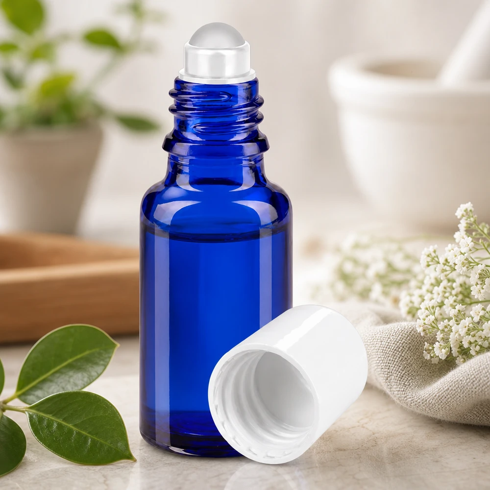 Flacon de pharmacie bleu 20ml Roll-On bouchon blanc Flacon roll-on bleu cobalt de 20 ml avec un bouchon à vis blanc ouvert, sur un fond de marbre clair