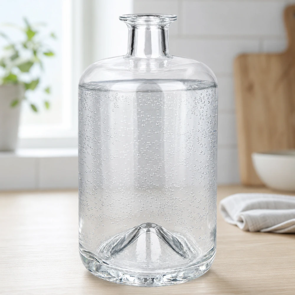 Flacon à pharmacie « Sofia » 700 ml sans bouchon UNiTWIST® Bouteille en verre Sofia de 700 ml remplie d'eau gazeuse montre des bulles de gaz dans un environnement de cuisine clair