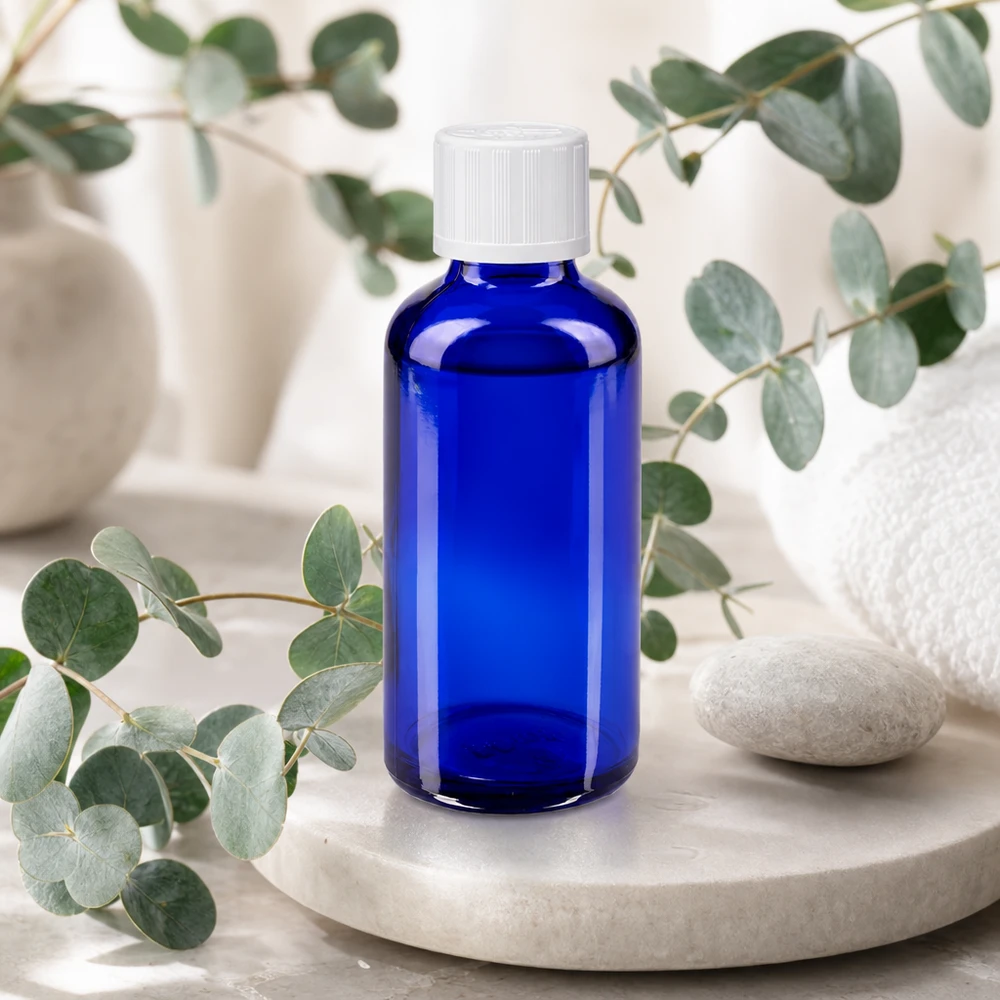 Flacon en verre bleu de 50 ml avec bouchon à vis blanc à l'épreuve des enfants, dans un décor de spa