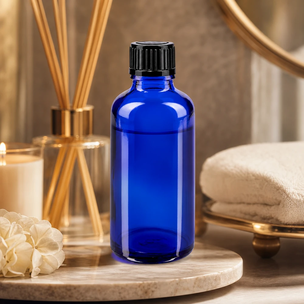 Flacon cylindrique en verre bleu de 50 ml avec un orifice de dosage de 1 mm et un bouchon noir nervuré