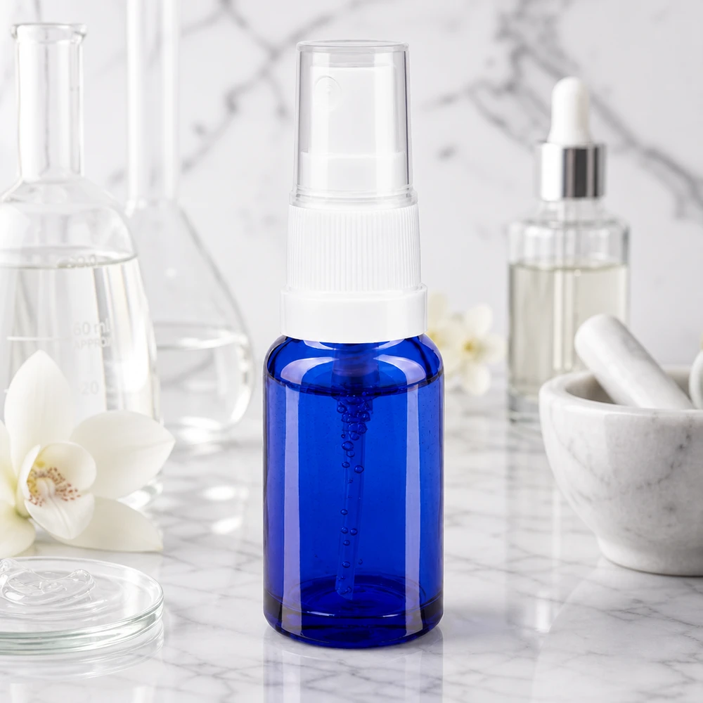 Flacon de pharmacie bleu 10ml embout spray blanc Petite bouteille en verre bleue avec un vaporisateur à pompe, à côté d'un flacon Erlenmeyer, d'un mortier et d'un sérum cosmétique
