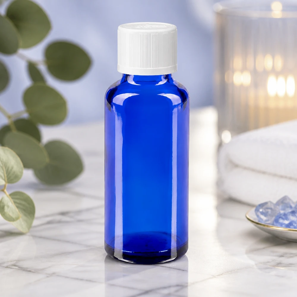Flacon à pharmacie bleu 30ml bouchon anti-goutte blanc séc. enf. std Flacon compte-gouttes bleu cobalt de 30 ml en verre anti-UV, muni d'un bouchon blanc à sécurité enfants, pour huiles essentielles