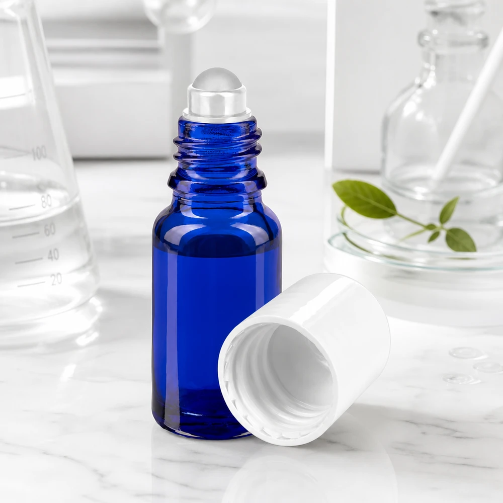 Flacon en verre d'apothicaire bleu ouvert de 10 ml, muni d'un applicateur à bille, à côté de matériel de laboratoire en verre