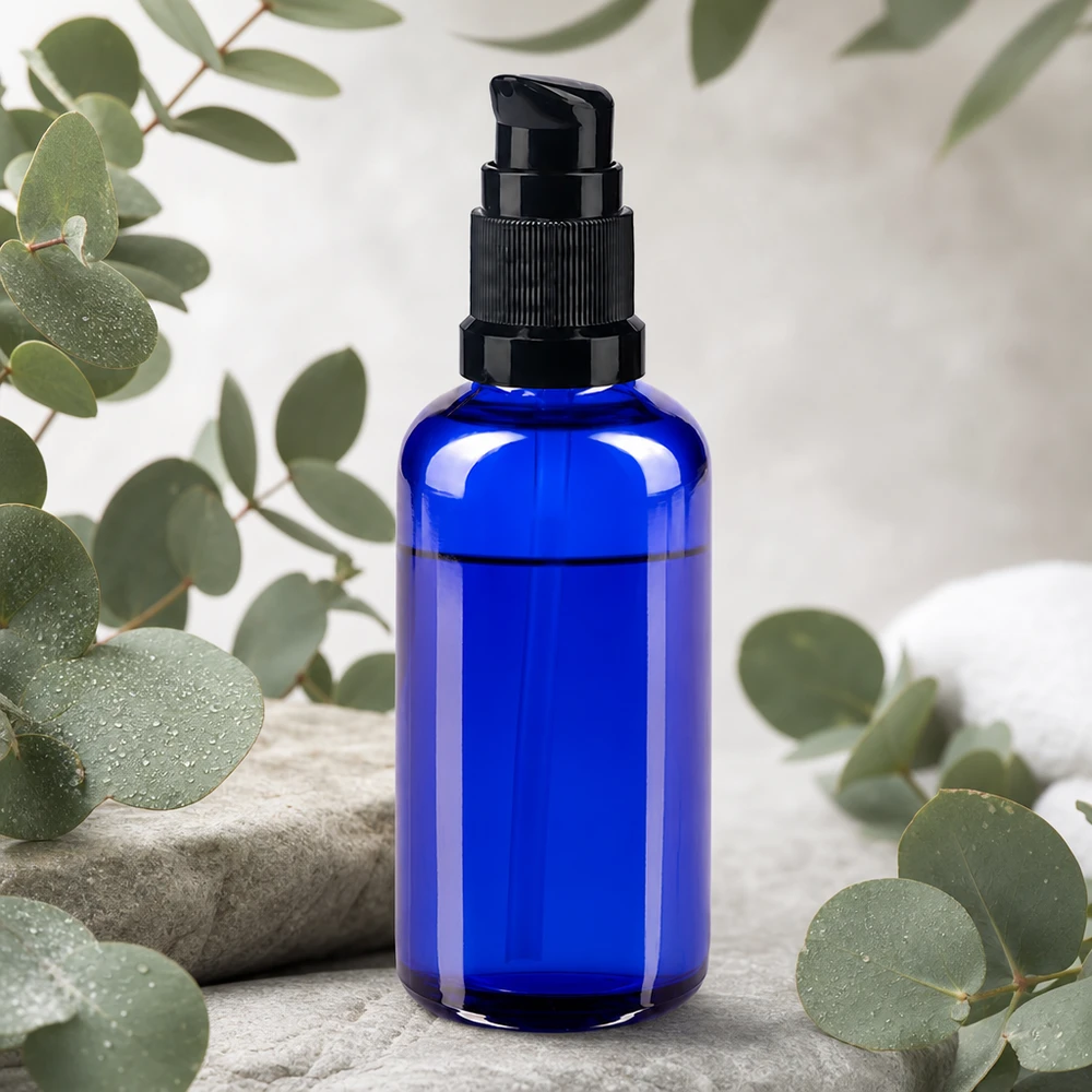 Flacon de pharmacie bleu de 50 ml muni d'une pompe doseuse noire, entouré de brindilles d'eucalyptus