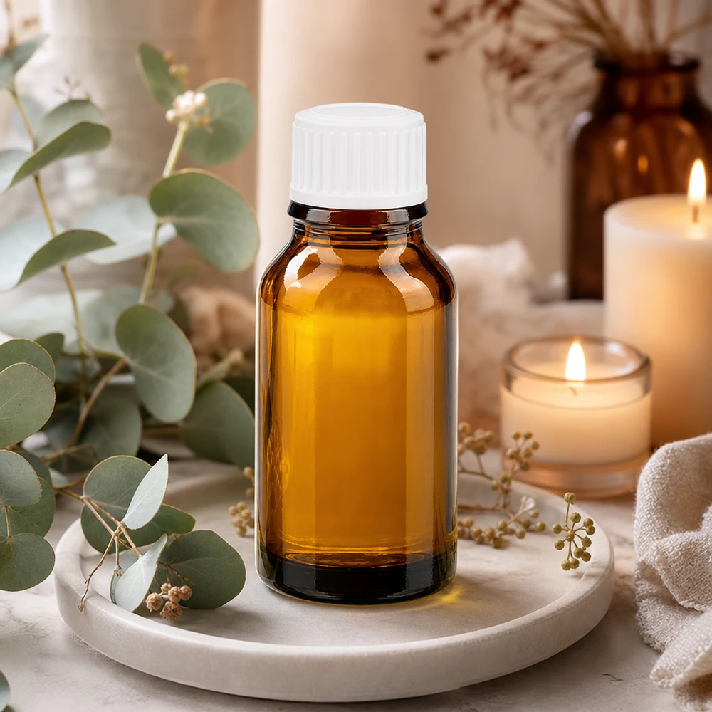 Flacon de pharmacie en verre ambré de 15 ml avec bouchon blanc, à côté de bougies et d'éléments de décoration naturels