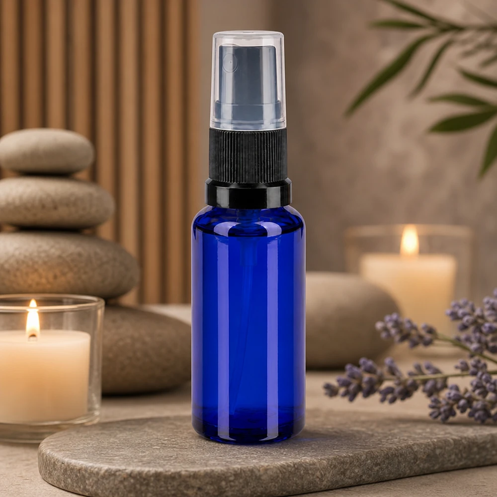 Flacon vaporisateur d'aromathérapie de 30 ml, bleu, avec bouchon transparent, à côté de fleurs de lavande et de bougies
