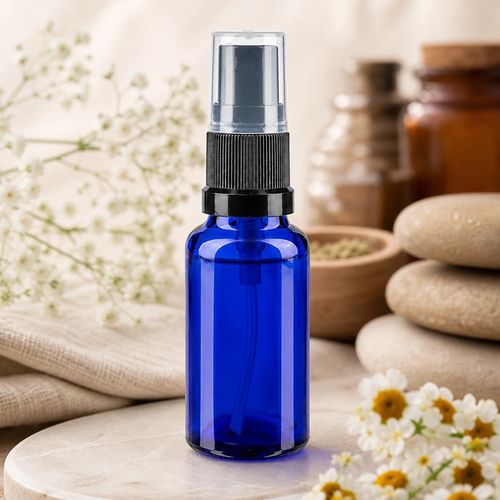 Petit flacon en verre bleu de 20 ml muni d'un vaporisateur à pompe, destiné à l'aromathérapie et aux soins de bien-être