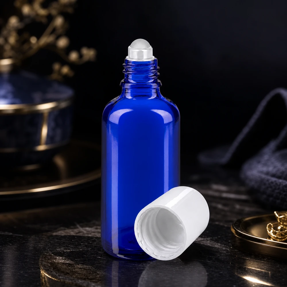 Flacon roll-on bleu de 50 ml STD, dont le bouchon blanc a été retiré, à côté d'accessoires dorés dans un cadre luxueux