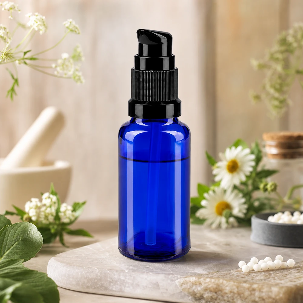 Flacon doseur bleu ApoGlas STD de 20 ml avec pompe noire, orné de fleurs de camomille