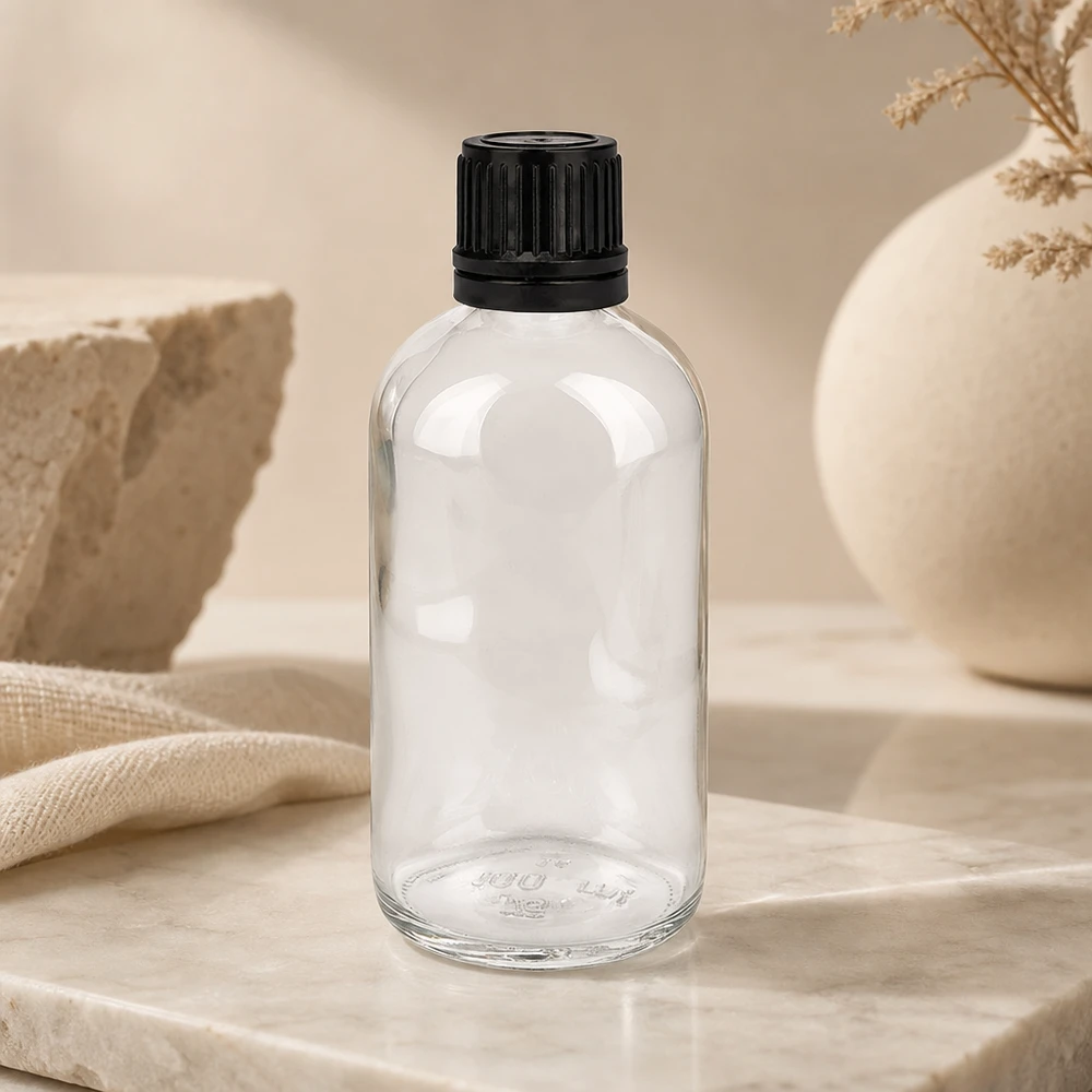 100ml (globule)Flas. 8mm GR s. STD ClearL. UT18/100 Flacon cylindrique en verre transparent de 100 ml avec un bouchon noir nervuré sur fond marbré