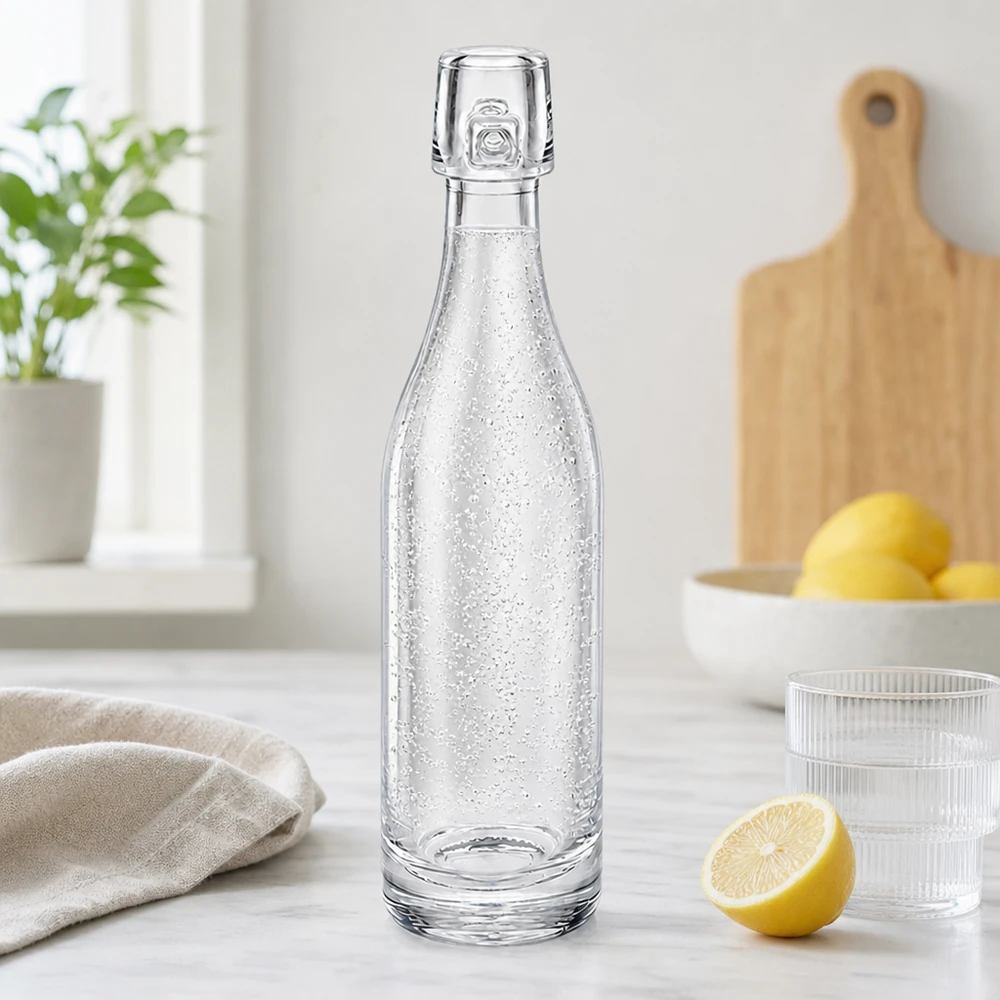 Bouteille en verre de 50 ml sans bouchon mécanique UNiTWIST Bouteille en verre de 50 ml UNiTWIST remplie d'eau gazeuse dans une cuisine moderne à côté de citrons et de verres Plan de travail blanc