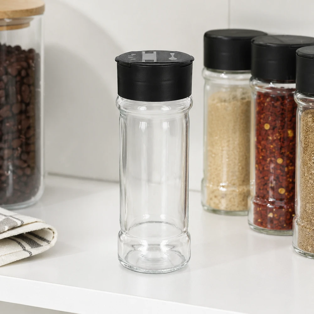 Pot à sel/épices 100 ml avec double saupoudreuse, noir Pot en verre transparent 100 ml avec couvercle saupoudreur noir, posé sur une étagère de cuisine blanche