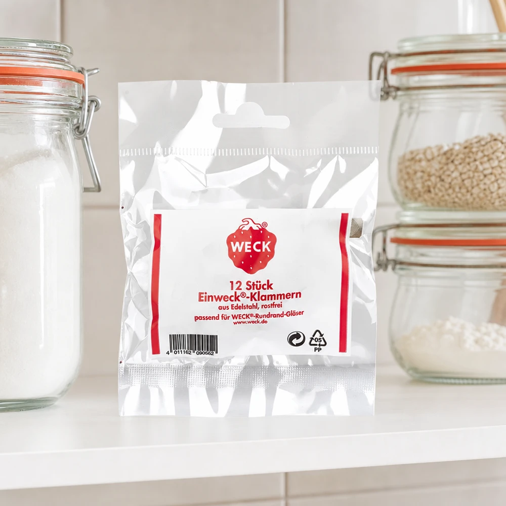 WECK Agrafes Emballage de produit dans la cuisine entre des bocaux de stockage avec de la farine de céréales sur un plan de travail blanc Ambiance cuisine