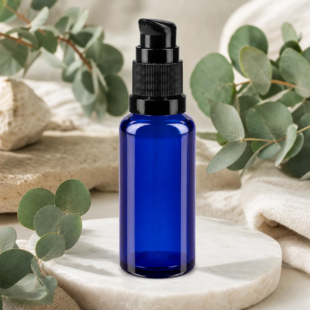 Flacon cylindrique en verre de 30 ml, bleu cobalt, avec une pompe noire et une décoration en forme d'eucalyptus