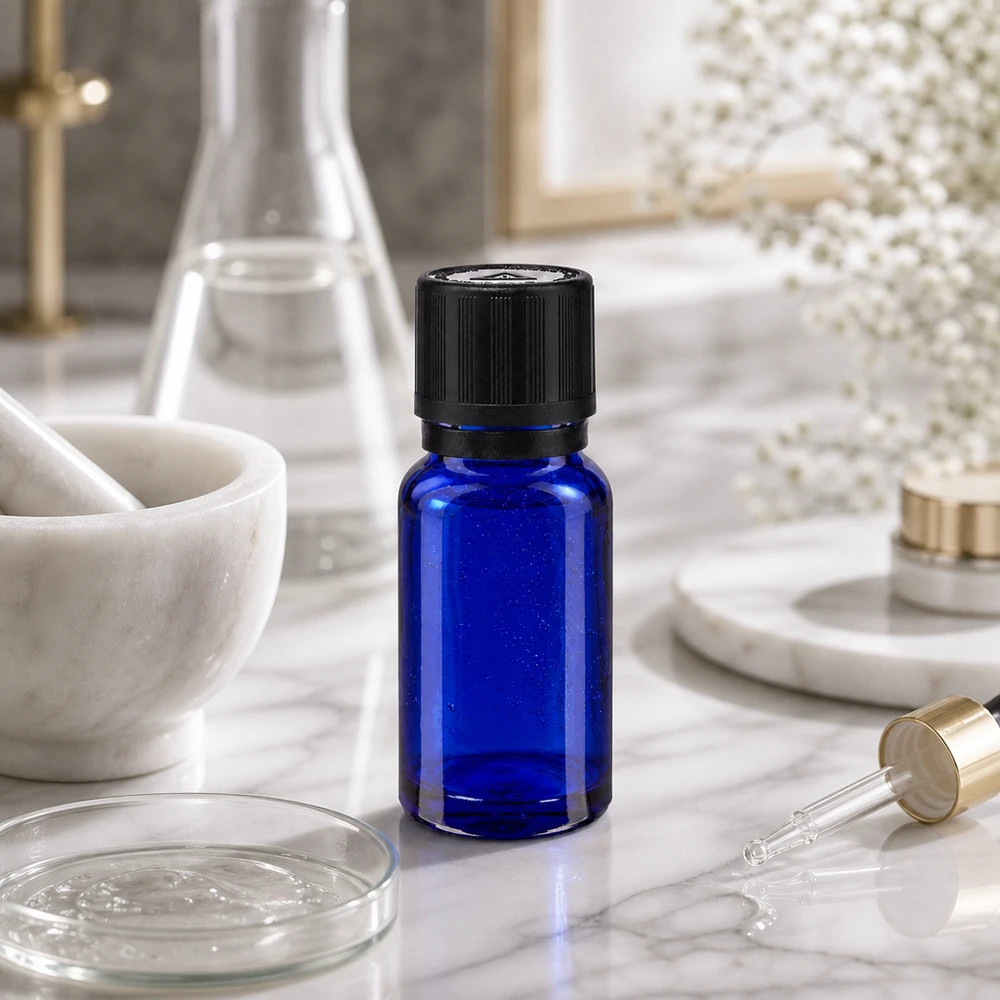 Flacon compte-gouttes bleu cobalt de 10 ml muni d'un bouchon KiSi, dans un environnement de laboratoire avec une boîte de Pétri et une pipette