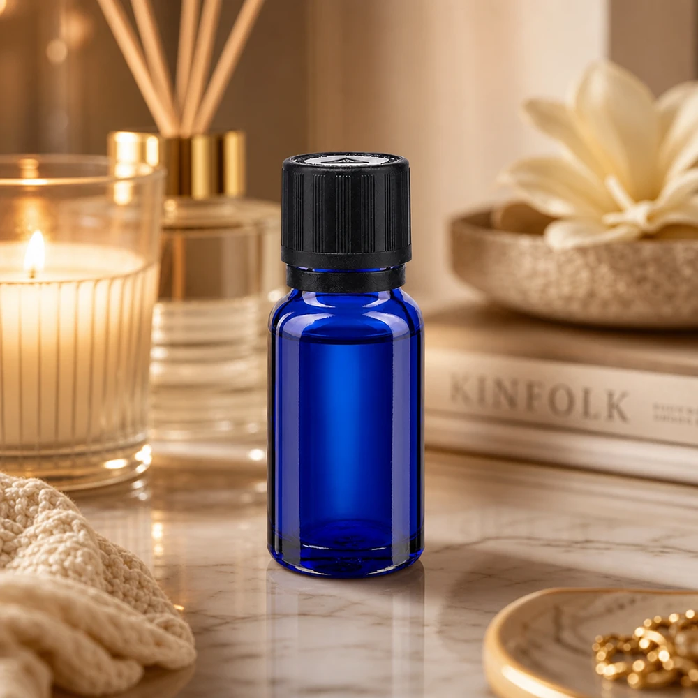 Flacon de pharmacie bleu 10ml bouchon inviolable blanc 1mm,séc. enf. bouchon inviolabilité Flacon compte-gouttes de 10 ml en verre de pharmacie bleu cobalt, à côté d'un diffuseur de parfum d'ambiance et d'une bougie