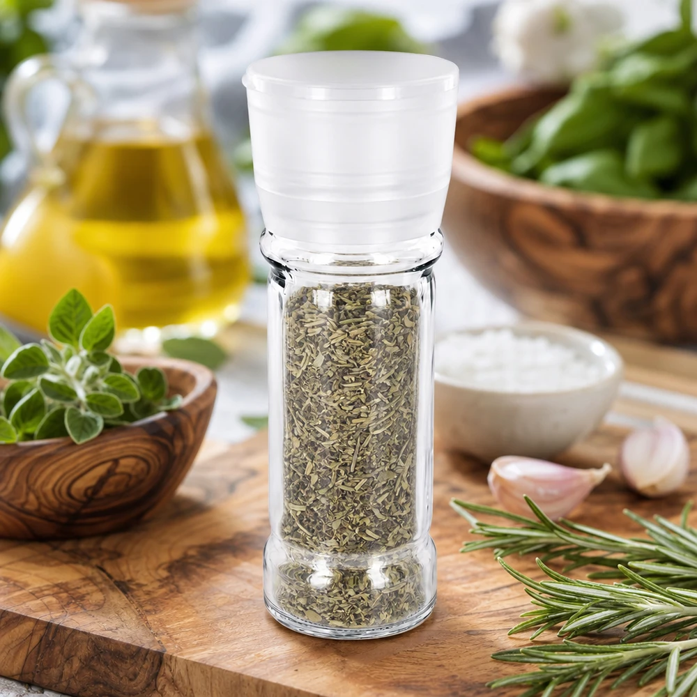 Pot à sel/épices 100 ml avec moulin Vario blanc Verre à broyer transparent de 100 ml avec moulin Vario et herbes séchées sur une planche en bois