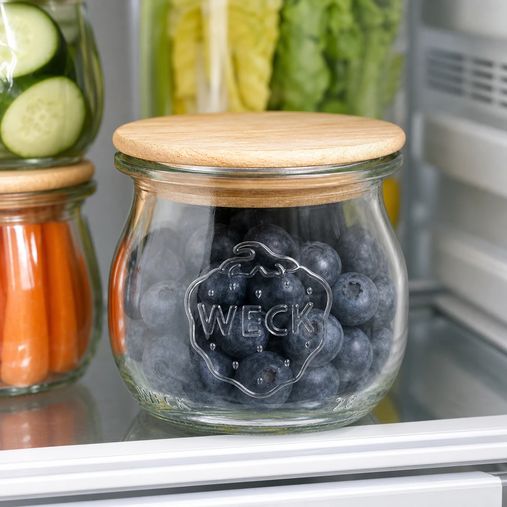 Pot tulipe 75ml WECK RR40 avec couvercle en bois WECK Pot tulipe RR40 75ml avec couvercle en bois rempli de myrtilles dans le réfrigérateur à côté d'autres bocaux à provisions