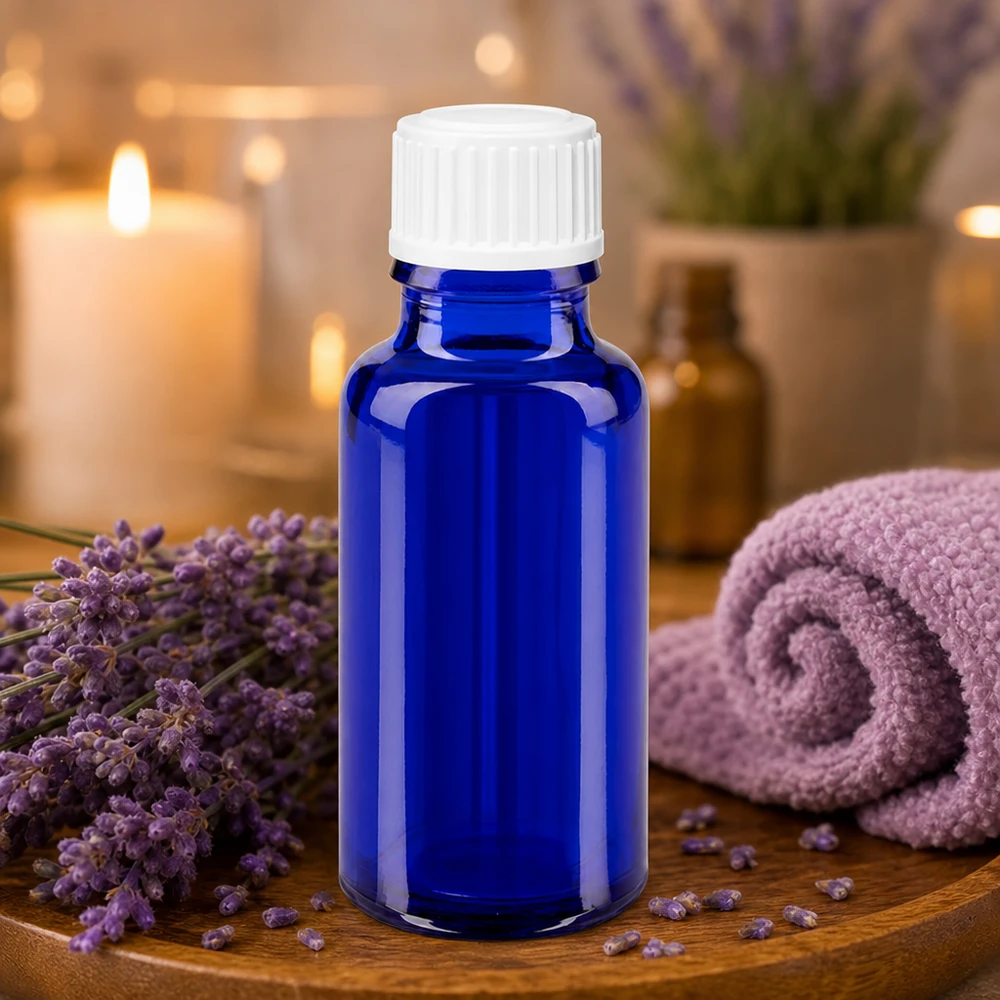 Petit flacon de pharmacie bleu de 20 ml, à côté d'un tissu roulé parfumé à la lavande et de bougies