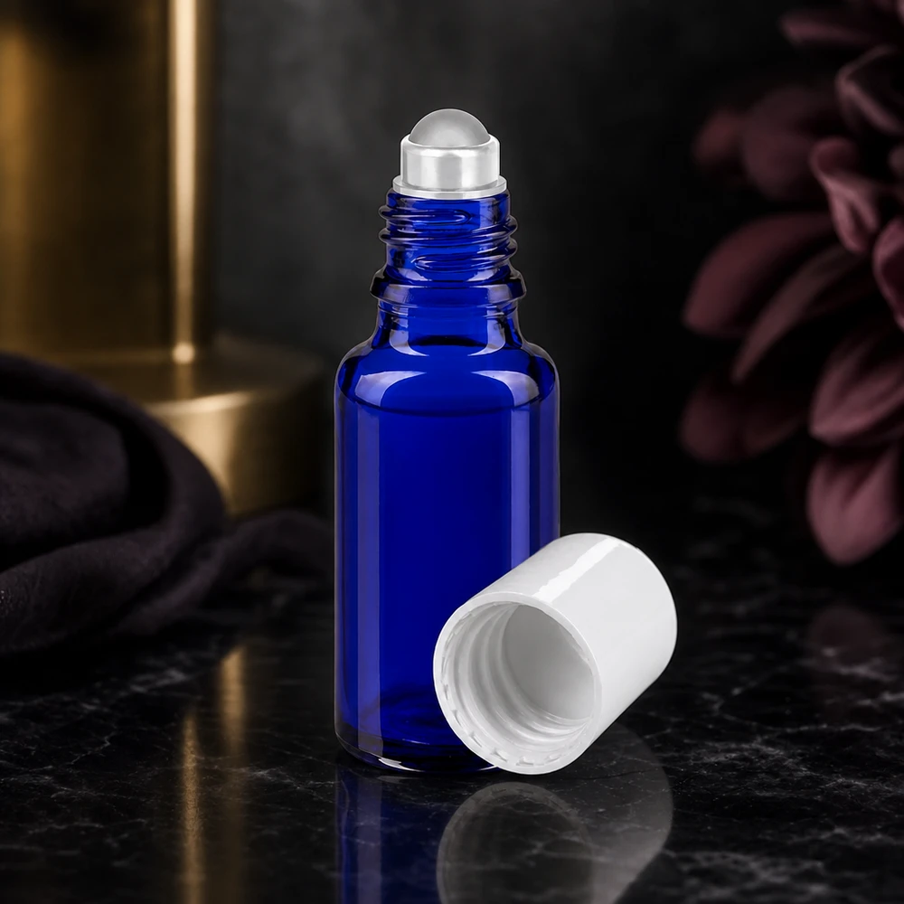 Flacon de pharmacie bleu 20ml Roll-On bouchon blanc Flacon en verre bleu cobalt de 20 ml avec bille roulante en acier inoxydable et bouchon blanc retiré, posé sur du marbre