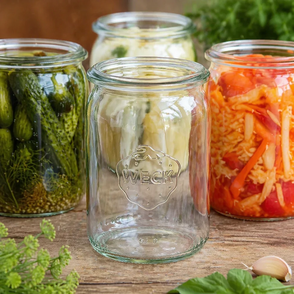 145ml bocal cylindrique WECK RR40 WECK Pot cylindrique 145ml RR40 vide entre les bocaux remplis de légumes marinés et de fermentation sur plateau en bois