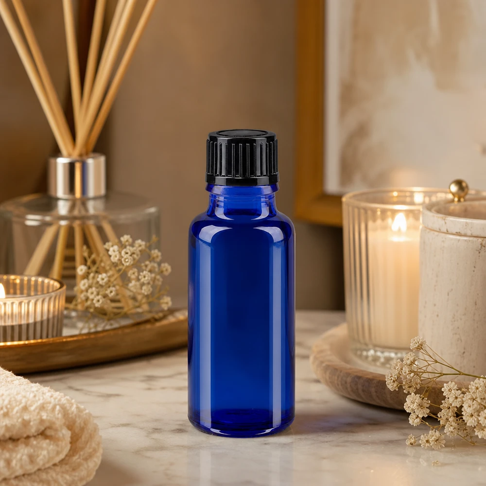 Flacon de pharmacie bleu de 20 ml avec un bouchon à vis noir, à côté de bougies et d'un parfum d'ambiance